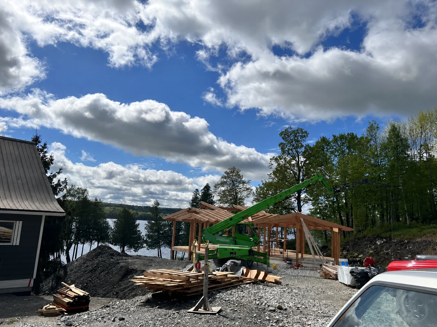 Vue d’ensemble du chantier riverain avec engin de levage et charpente en cours de montage