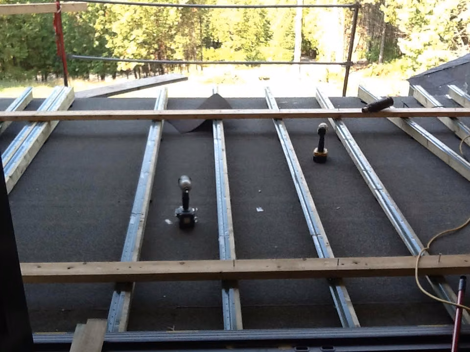 Surface en cours de préparation avec profilés métalliques et outils sur le chantier