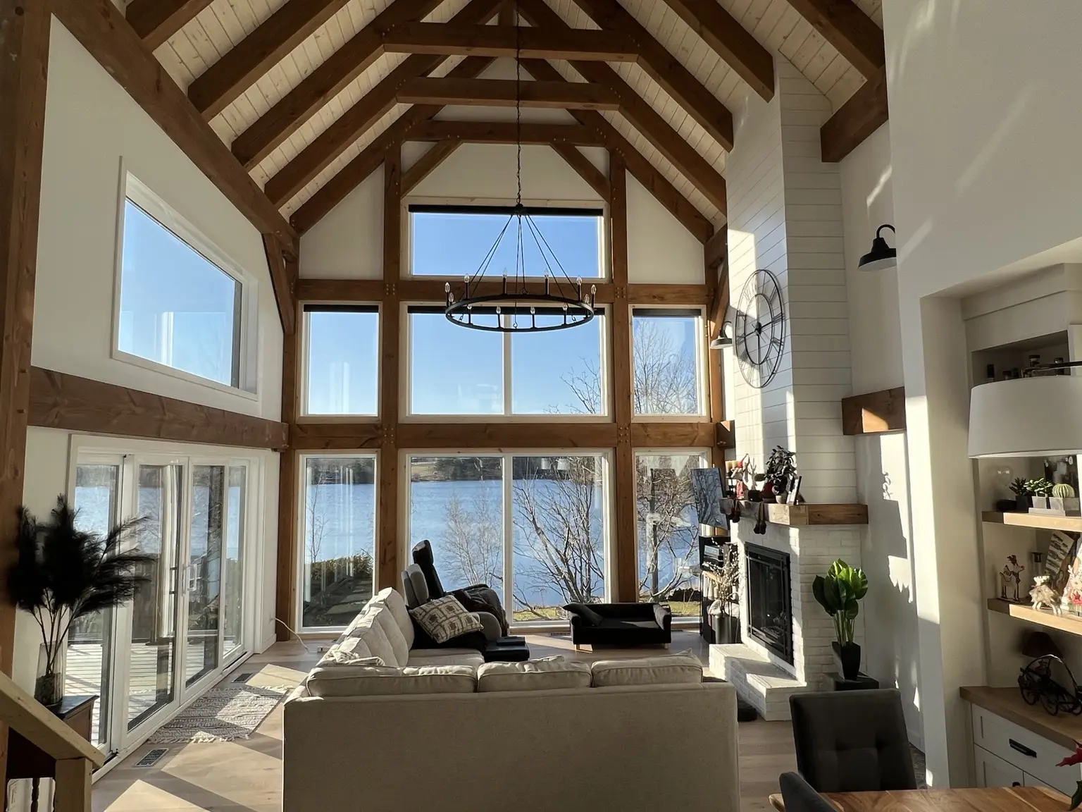 Intérieur contemporain ouvert sur le lac, structuré par une charpente en bois massif