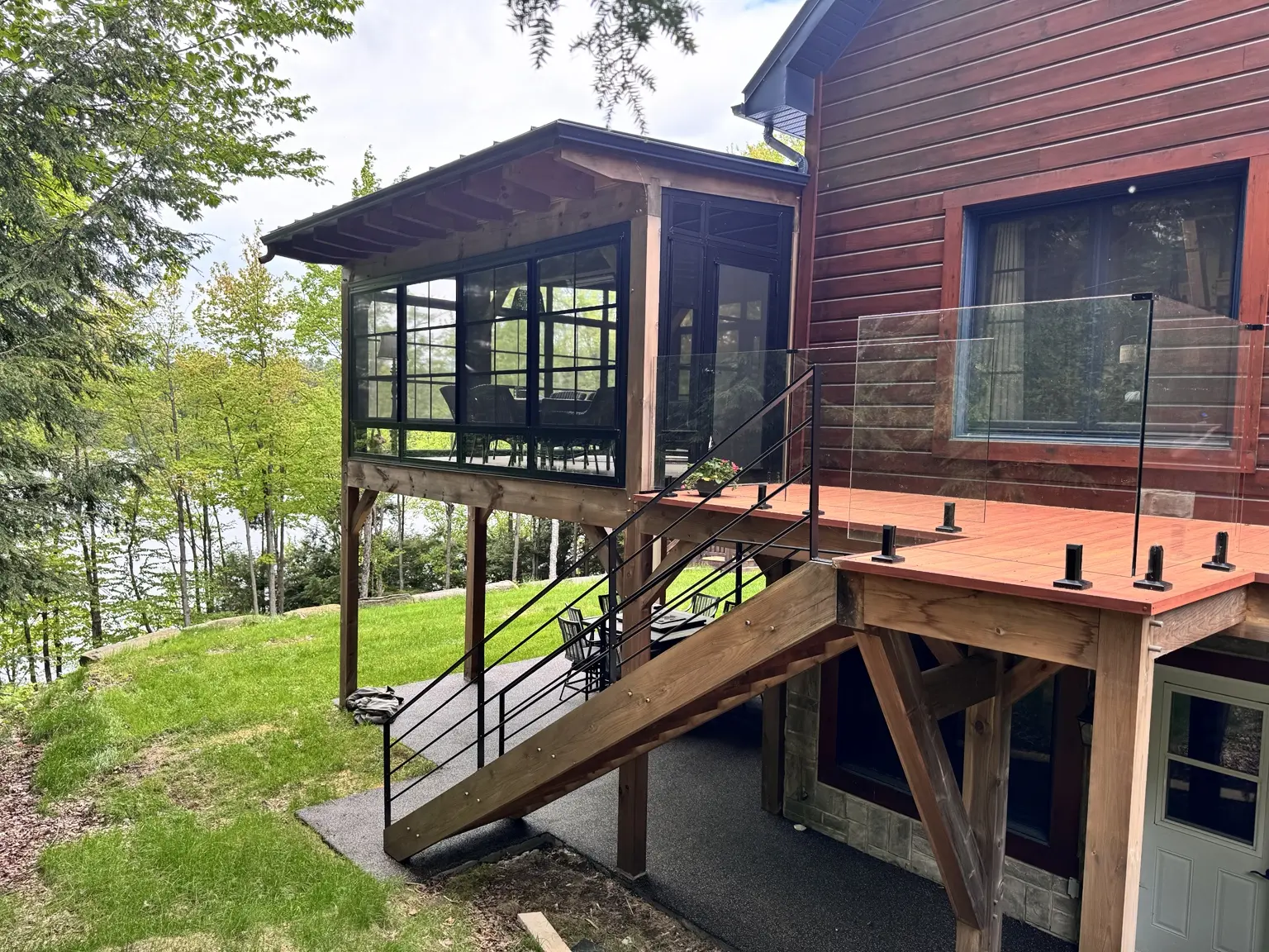 Extension contemporaine en bois et verre intégrée à une résidence au bord du lac