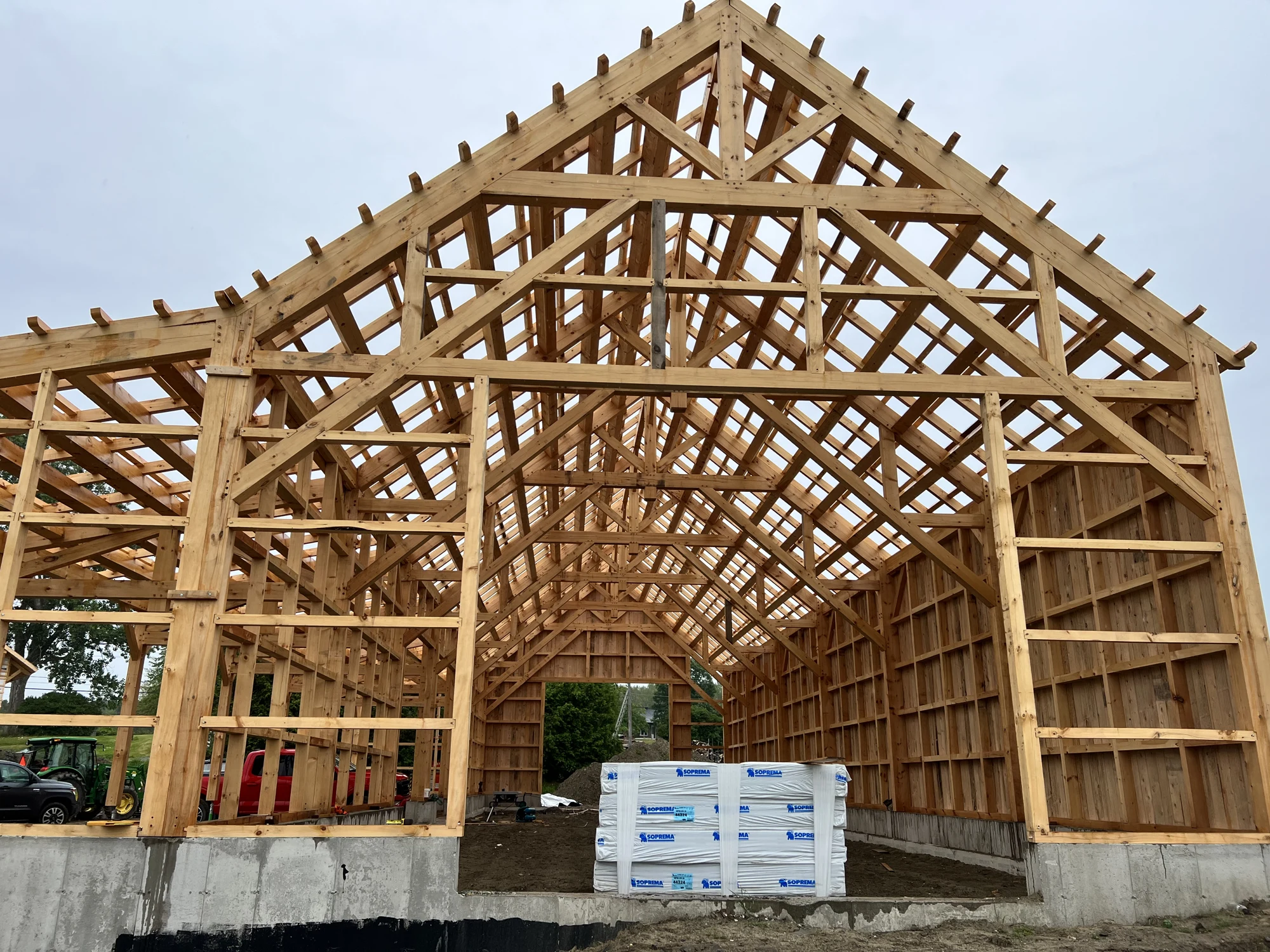 Vue extérieure de la grande charpente de grange sur ses fondations en béton
