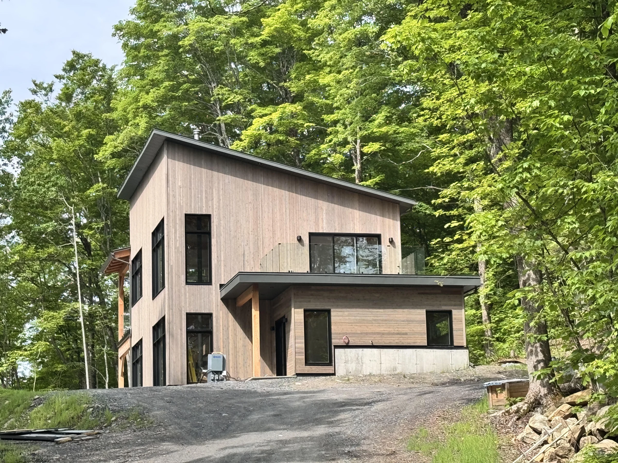Résidence contemporaine à revêtement de bois entourée de forêt